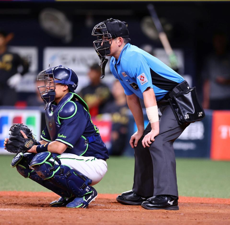 　梅木球審は投球が腕に当たりテーピングしジャッジする（撮影・山口登）