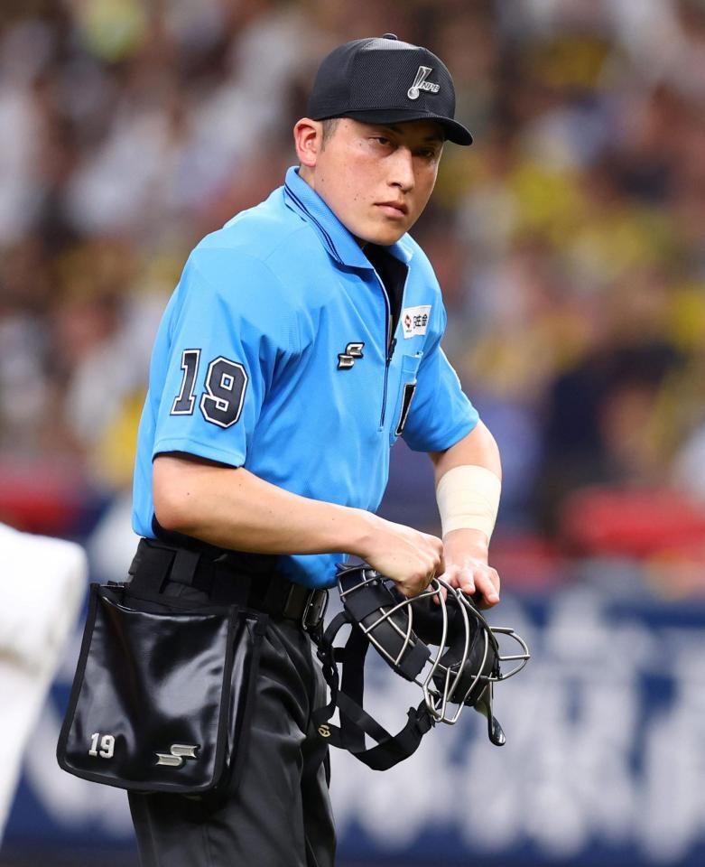 　梅木球審は投球が腕に当たりテーピングしジャッジする（撮影・山口登）