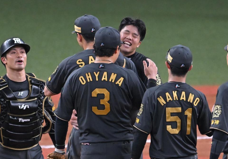 　佐藤輝と抱擁する才木（撮影・飯室逸平）