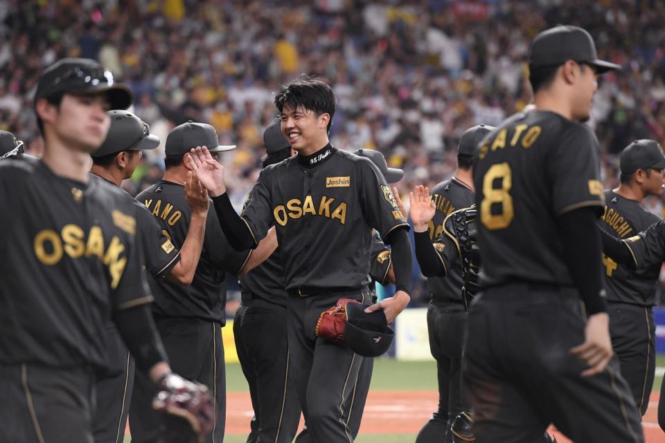 　完投勝利し、笑顔でナインとタッチを交わす才木（中央）＝撮影・西田忠信