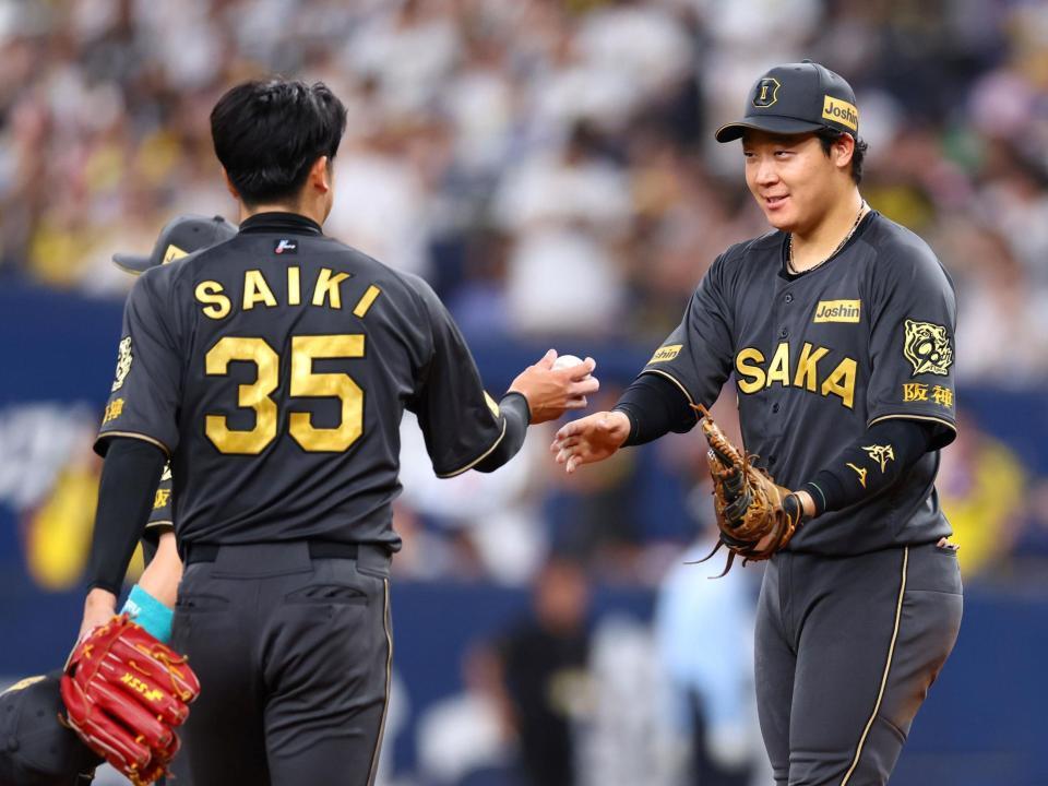 　才木（左）にウイングボールを手渡す大山（撮影・山口登）