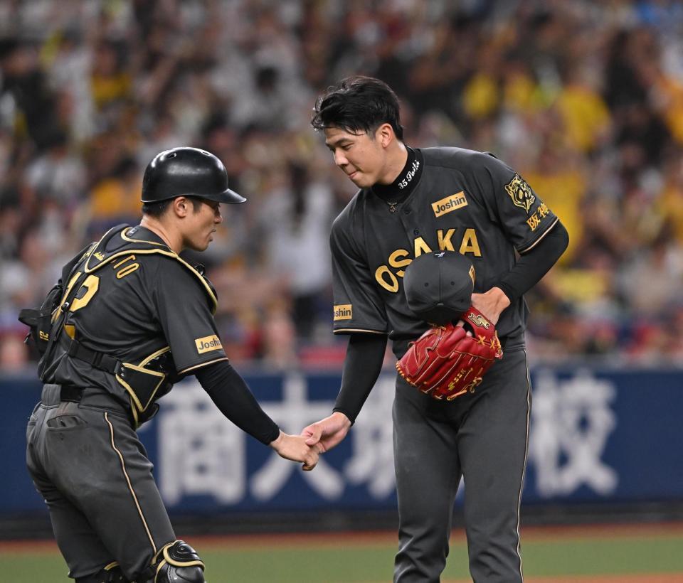 　完投勝利し、坂本（左）と握手する才木（撮影・西田忠信）