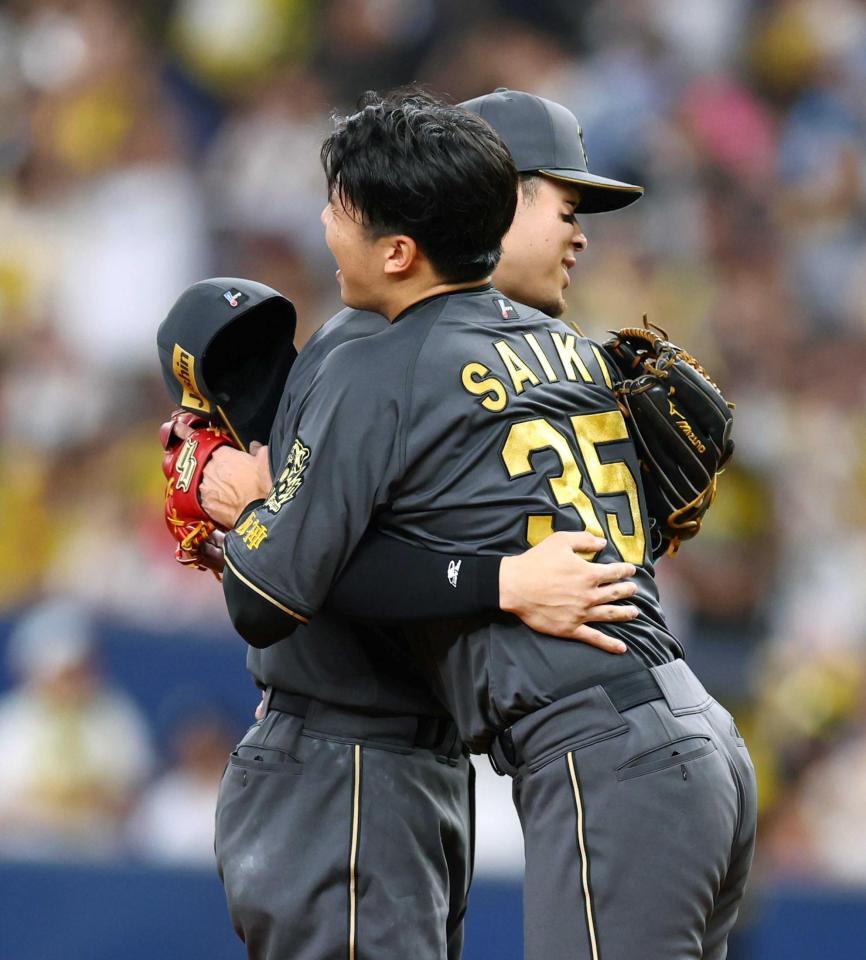 　完投勝利を飾った才木（左）と抱き合う佐藤輝（撮影・山口登）