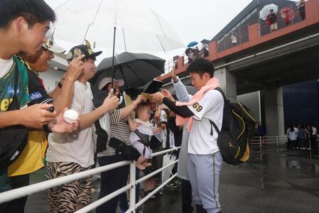 　天候不良で試合中止となり、ファンにサインする石井（撮影・北村雅宏）