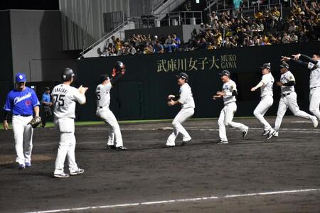 　サヨナラ打を放ち、ナインに迎えられる佐野