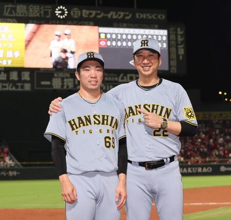 　３９試合連続無失点を達成し、藤川監督（右）から祝福される石井（撮影・北村雅宏）