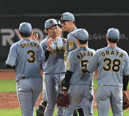 　３９試合連続無失点のセ・リーグ新記録を達成した石井を労う佐藤輝（撮影・飯室逸平）