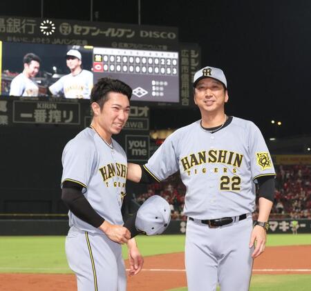 　３９試合連続無失点を達成し、藤川監督（右）から祝福される石井（撮影・北村雅宏）