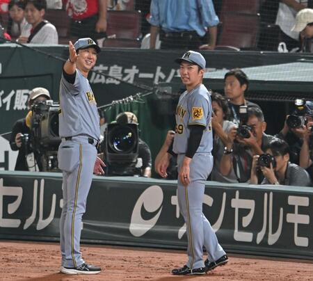 　３９試合連続無失点のセ・リーグ新記録を達成した石井（右）を祝福する藤川監督（撮影・飯室逸平）