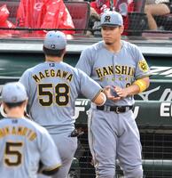 　守備から戻る前川（５８）をベンチで迎える佐藤輝（撮影・飯室逸平）