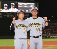 　３９試合連続無失点を達成し、藤川監督（右）と写真に納まる石井（撮影・北村雅宏）