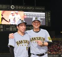 　３９試合連続無失点を達成し、藤川監督（右）から祝福される石井（撮影・北村雅宏）