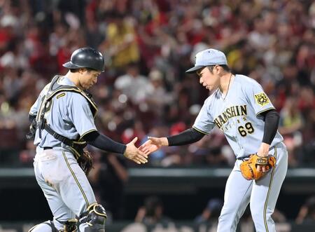 　９回を無失点で締め、坂本と握手をする石井（撮影・市尻達拡）