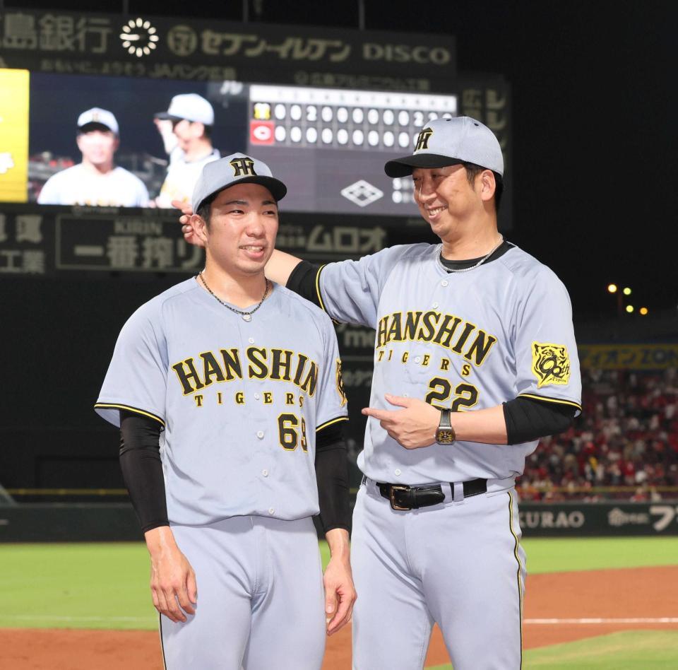 　３９試合連続無失点を達成し、藤川監督（右）から祝福される石井（撮影・北村雅宏）