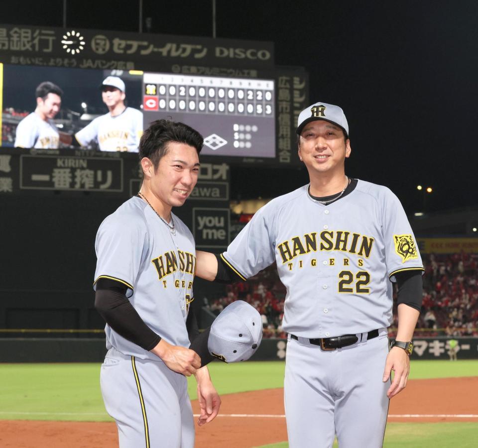 　３９試合連続無失点を達成し、藤川監督（右）から祝福される石井（撮影・北村雅宏）