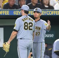 　７回、同点２ランを浴びたハートウィグ（左）をねぎらう伊藤将（撮影・西岡正）