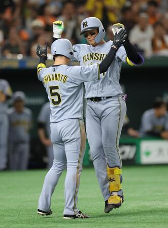 　１回、先制２ランを放ち、近本（左）とタッチを交わす森下（撮影・西岡正）