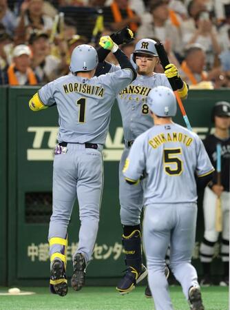 　１回、先制２ランを放ち、佐藤輝（右）とタッチを交わす森下（撮影・西岡正）