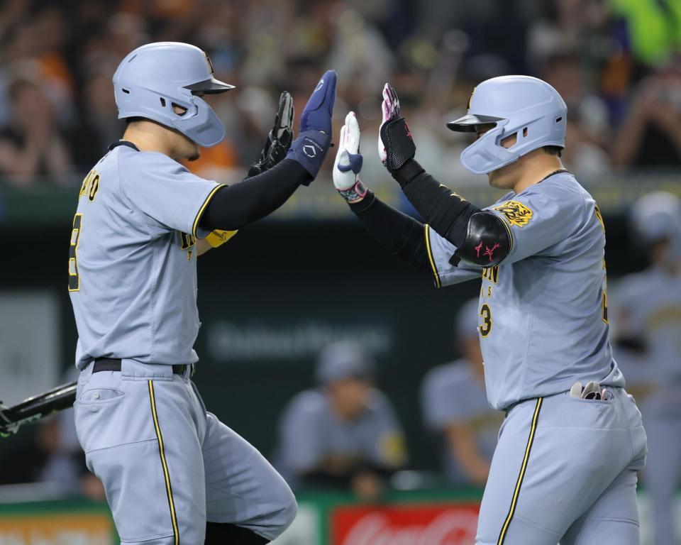 　４回、先制２ランを放ち、佐藤輝（左）とタッチを交わす大山（撮影・西岡正）