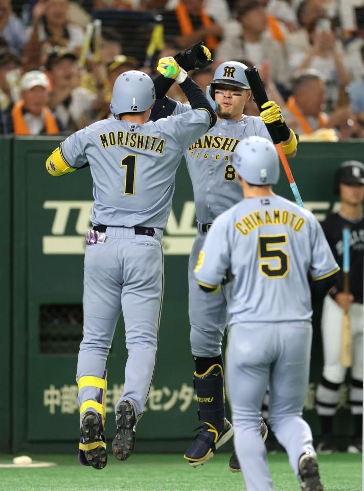 　１回、先制２ランを放ち、佐藤輝（右）とタッチを交わす森下（撮影・西岡正）