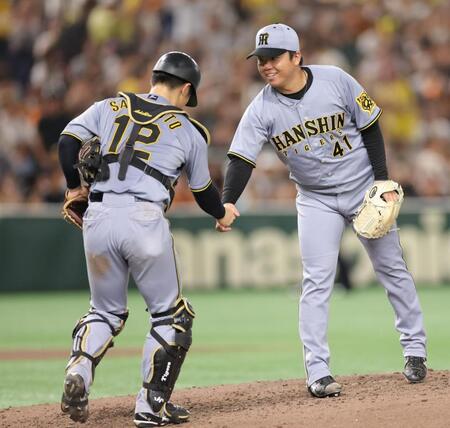 　完封勝利で坂本（左）と握手する村上（撮影・西岡正）