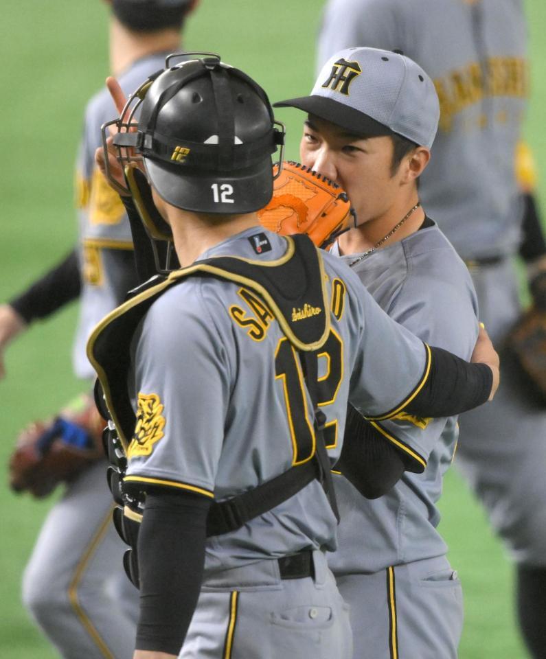 　８回を投げ終え、坂本（左）にねぎらわれる石井（撮影・伊藤笙子）