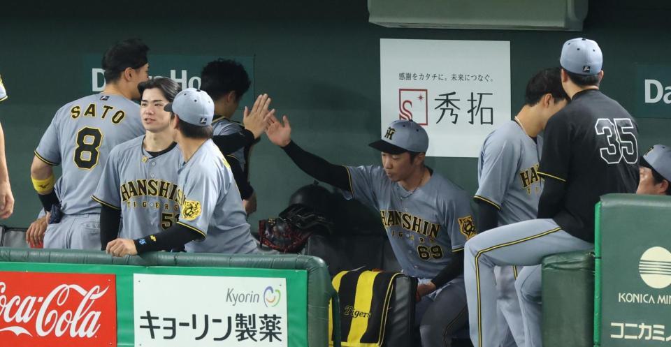 　８回、無失点に抑え佐藤輝とタッチする石井（撮影・金田祐二）