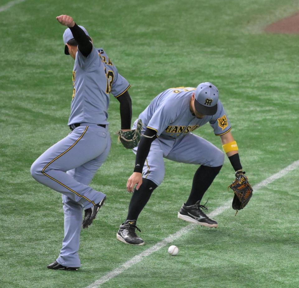 　９回、増田大がバントした打球を見送る三塁手・佐藤輝（左は岩崎）＝撮影・伊藤笙子