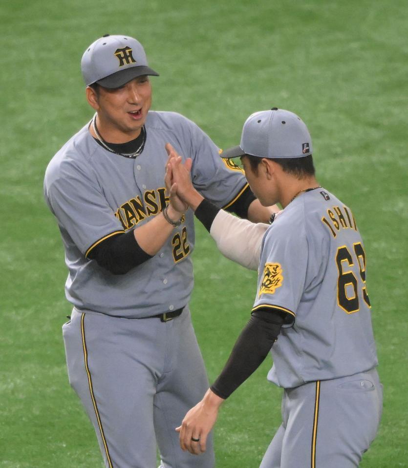　４０試合連続無失点のＮＰＢ記録を樹立した石井（右）と笑顔でハイタッチする藤川監督（撮影・伊藤笙子）