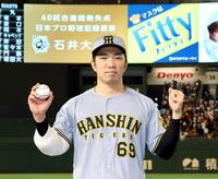 　偉業を祝福するビジョンを背にポーズを決める石井（撮影・田中太一）