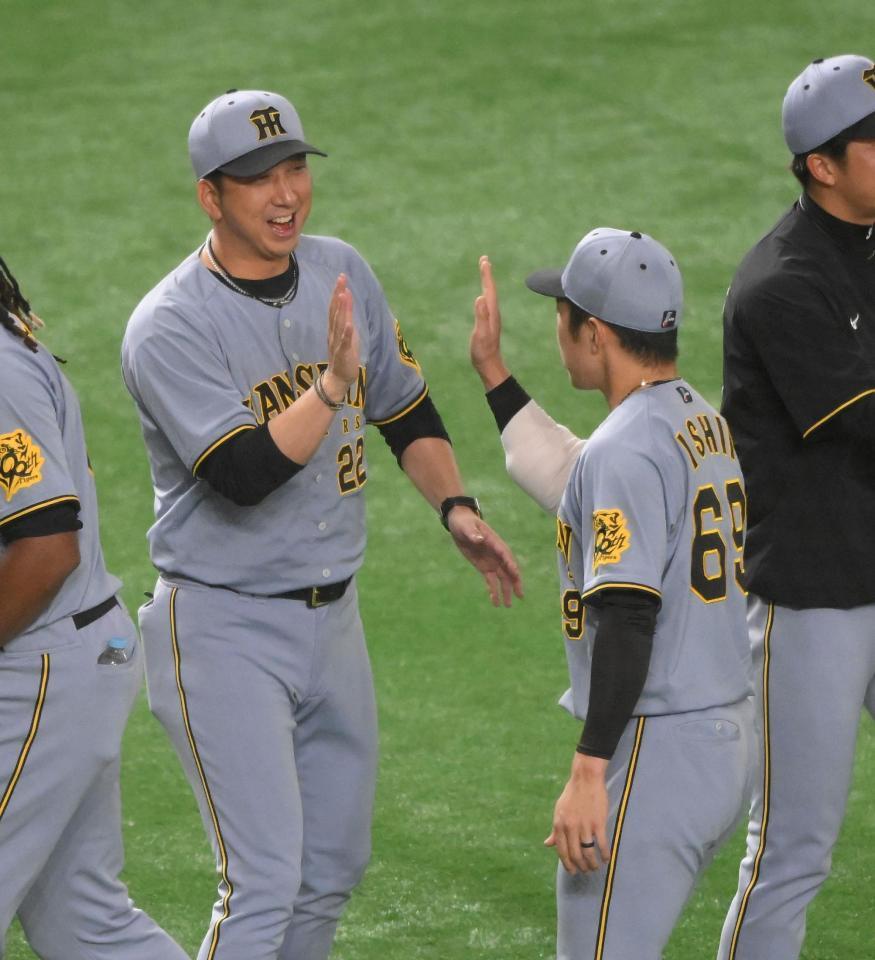 　４０試合連続無失点のＮＰＢ記録を樹立した石井（右）と笑顔でハイタッチする藤川監督（撮影・伊藤笙子）