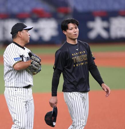 　野村コーチと話しながら練習に向かう栄枝（右）