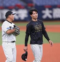 　野村コーチと話しながら練習に向かう栄枝（右）