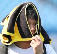 　タオルを顔に巻いて球場入りする森下（撮影・田中太一）