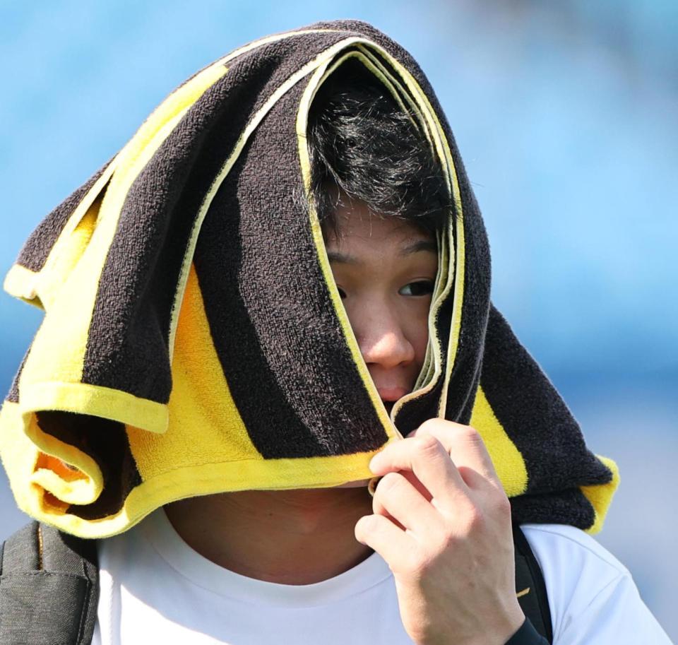 　タオルを顔に巻いて球場入りする森下（撮影・田中太一）