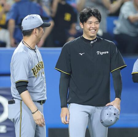 　藤川監督（左）に力投をねぎらわれ、笑顔を見せる才木（撮影・西岡正）