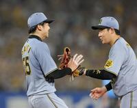 　５回、ピンチをしのぎ、大山（右）とタッチを交わす才木（撮影・西岡正