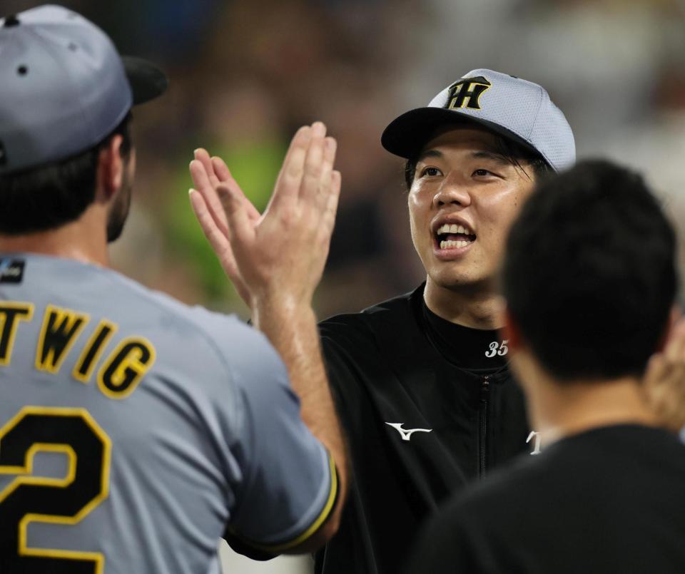 　９回を締めたハートウィグとタッチを交わす才木（撮影・田中太一）
