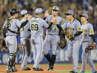 　ＤｅＮＡに勝利し、佐藤輝（左から４人目）、大山（同５人目）らとタッチを交わす石井（６９）＝撮影・西岡正