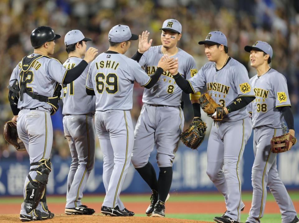 　ＤｅＮＡに勝利し、佐藤輝（左から４人目）、大山（同５人目）らとタッチを交わす石井（６９）＝撮影・西岡正