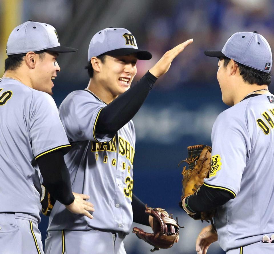 　ピンチを好守で救い大山（右）らと喜び合う小幡（中央）＝撮影・田中太一