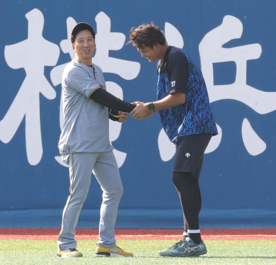 藤川監督（左）の元へ駆けつけ、握手する藤浪（撮影・西岡正）