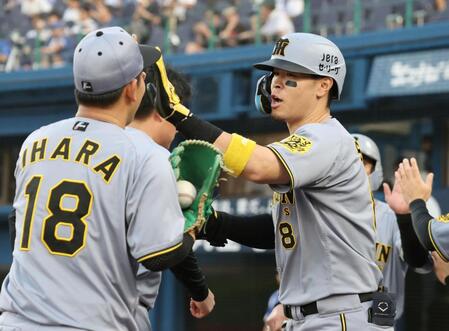 　１回、２ランを放った佐藤輝は伊原とタッチを交わす（撮影・田中太一）