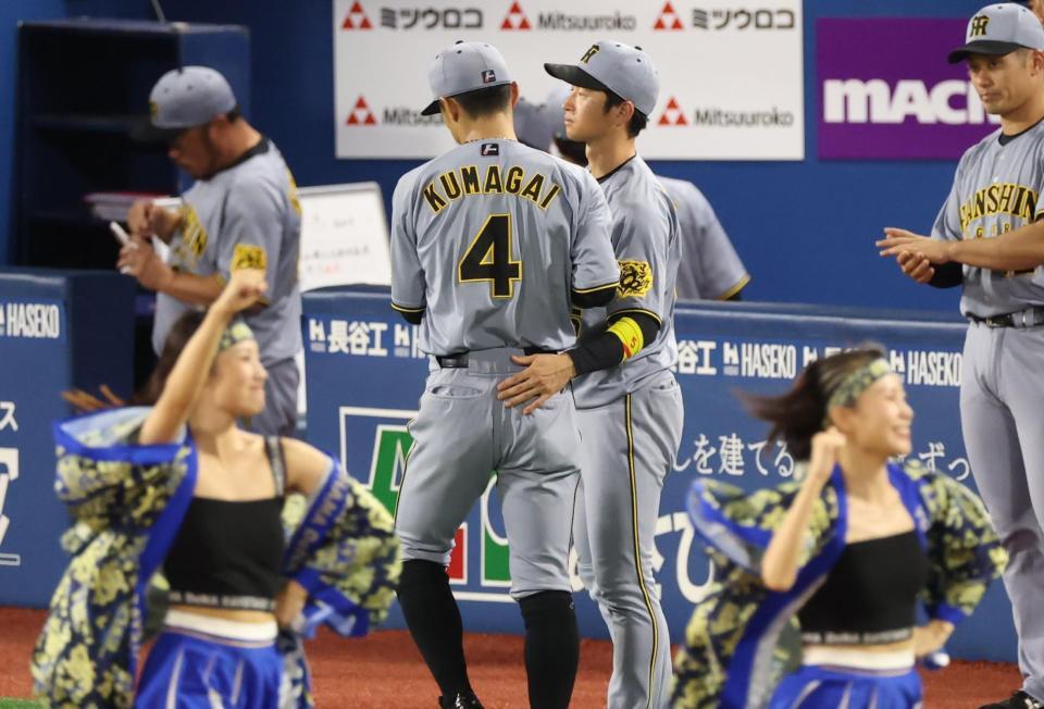 　４回の守備を終えた熊谷を迎える近本（撮影・金田祐二）