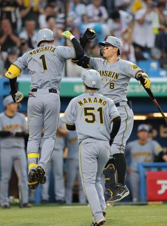 　１回、先制２ランを放ち、佐藤輝（右）とタッチを交わす森下＝２３日