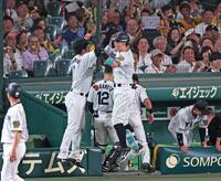 　８回、２者連続となるソロアーチを放ち、ベンチ前で森下（中央左）とタッチを交わす佐藤輝（撮影・立川洋一郎）