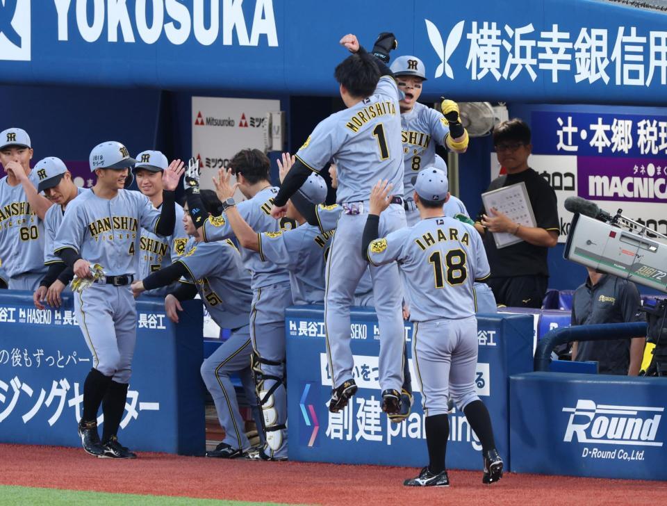 　１回、先制２ランを放ちナインに迎えられる佐藤輝と二走・熊谷＝２８日