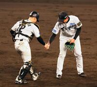 　試合を締め、坂本（左）と握手をする岩崎（撮影・山口登）