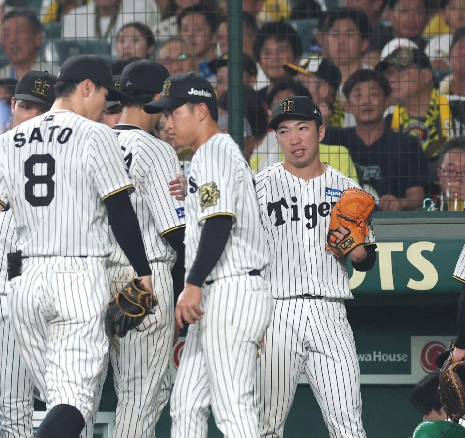 　８回を三者凡退に抑え、ナインを迎える石井（右）＝撮影・北村雅宏