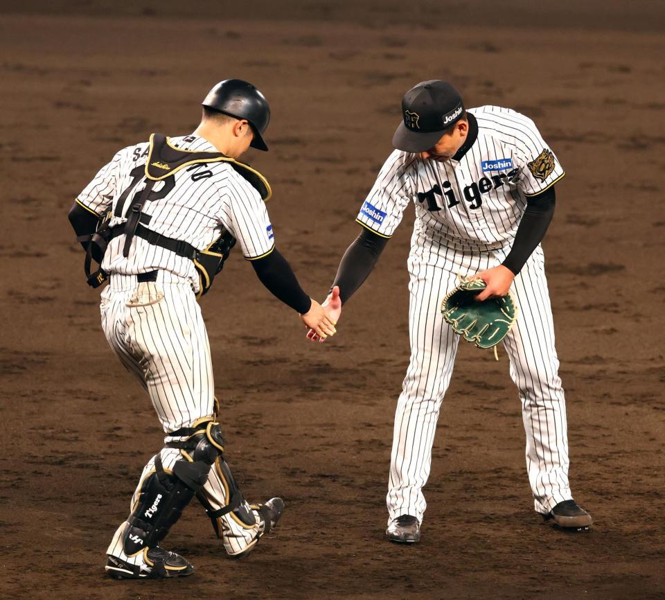 　試合を締め、坂本（左）と握手をする岩崎（撮影・山口登）